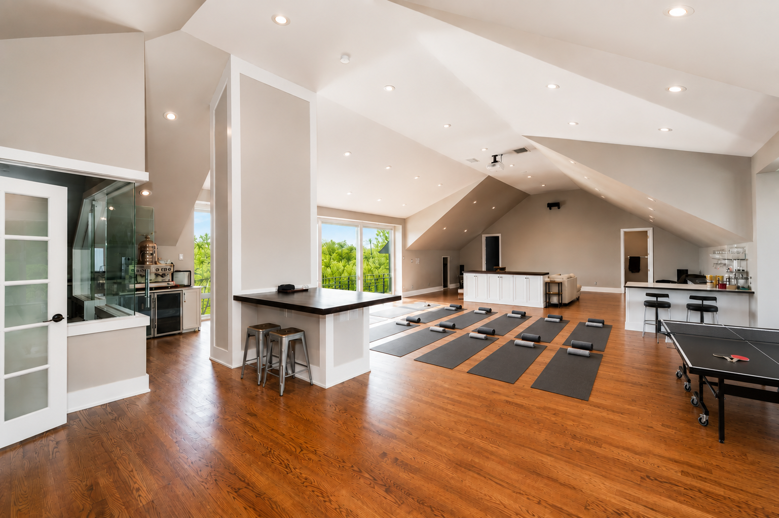 Open studio with yoga mats laid out, vaulted ceiling and a coffee bar